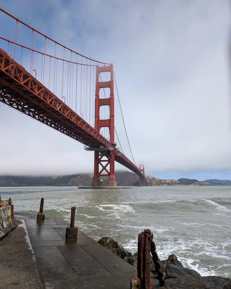 The Golden Gate Bridge in the fog, seen from the shore